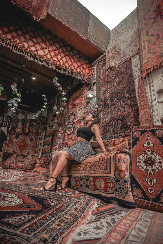 a woman sits on top of a bed covered in carpet