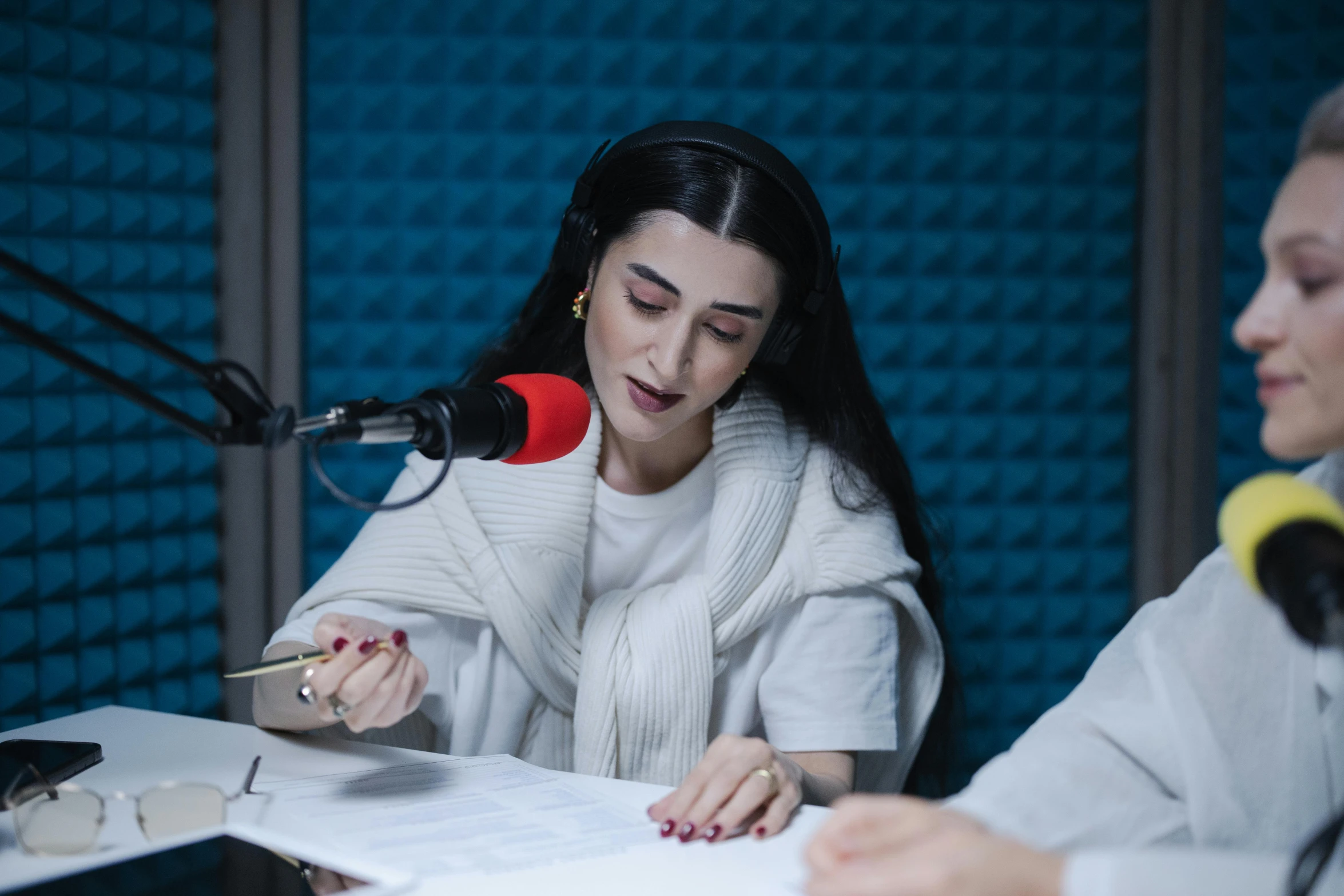 a woman sitting at a table with a microphone