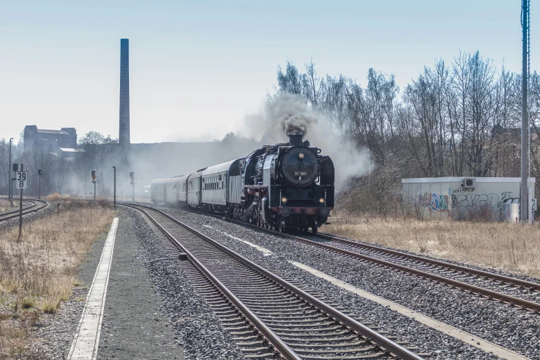 a train traveling down tracks next to trees