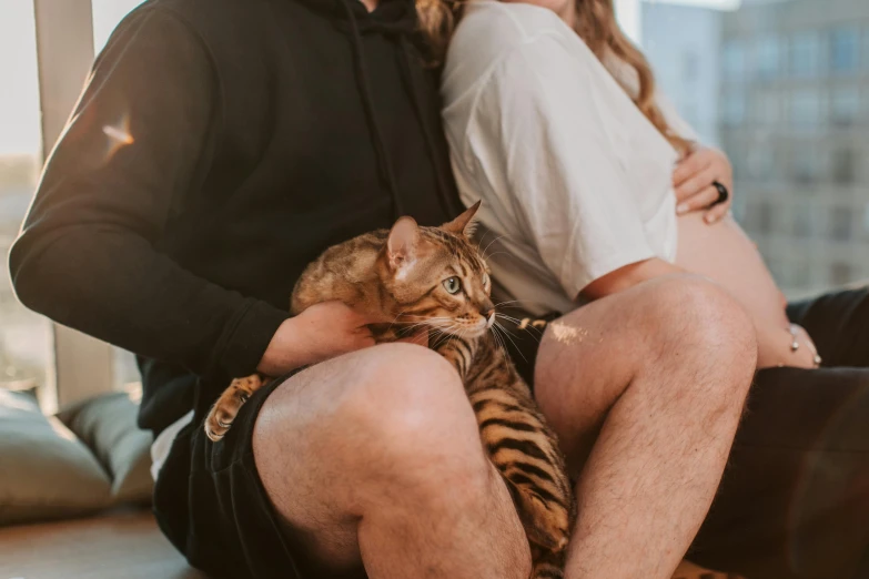 a man and woman are holding their cat together