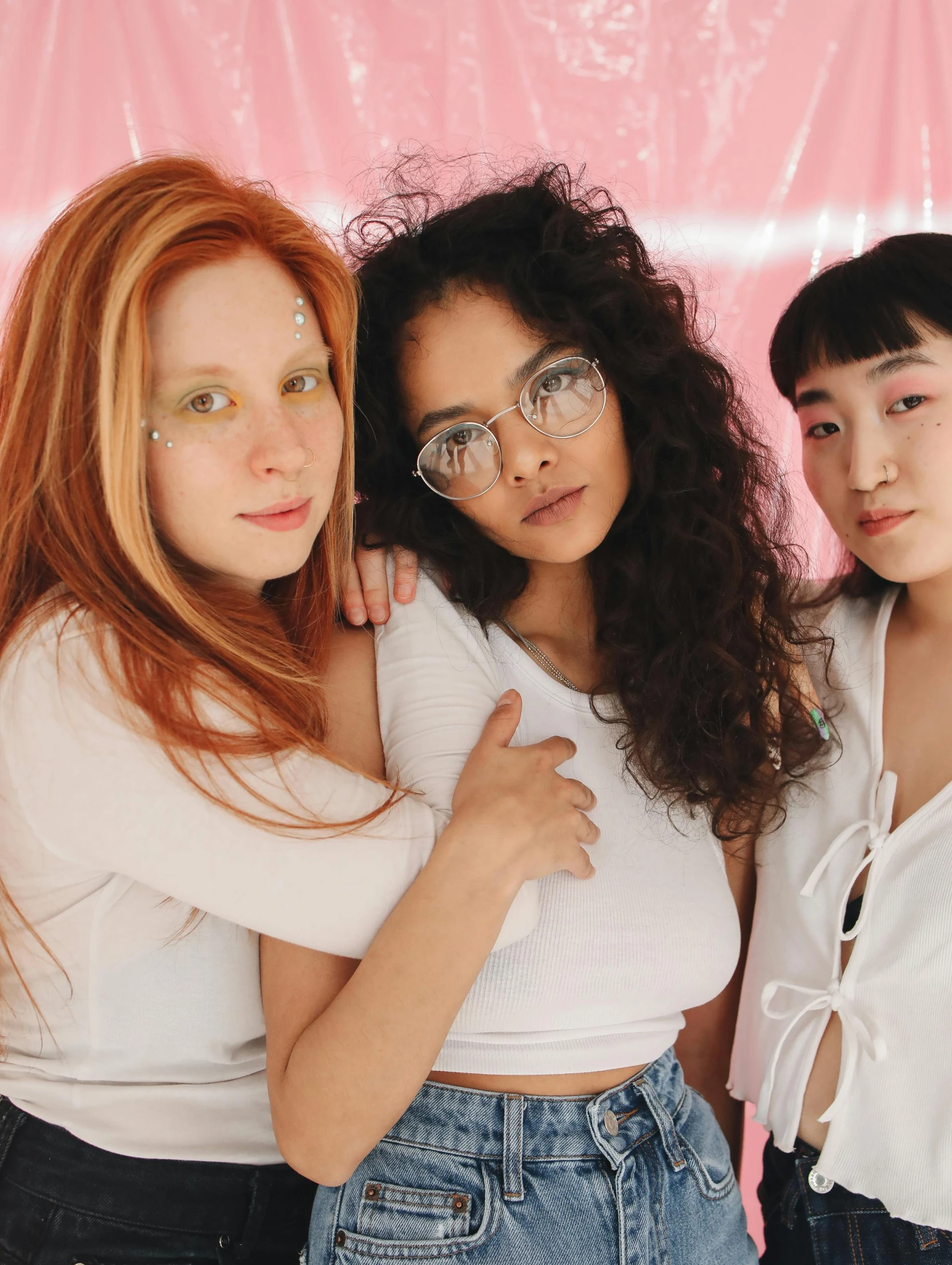 three s posing in front of a pink backdrop