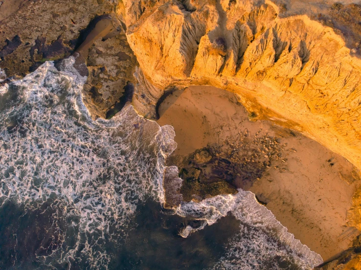 an aerial view of rocks and cliffs next to the ocean