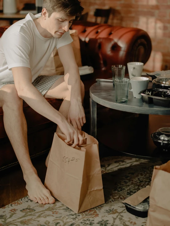 a young man is sitting on the couch with his shoes off