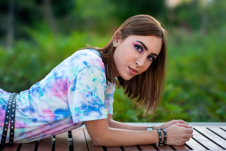 a beautiful young woman leaning on a wooden table with her hand resting on her stomach