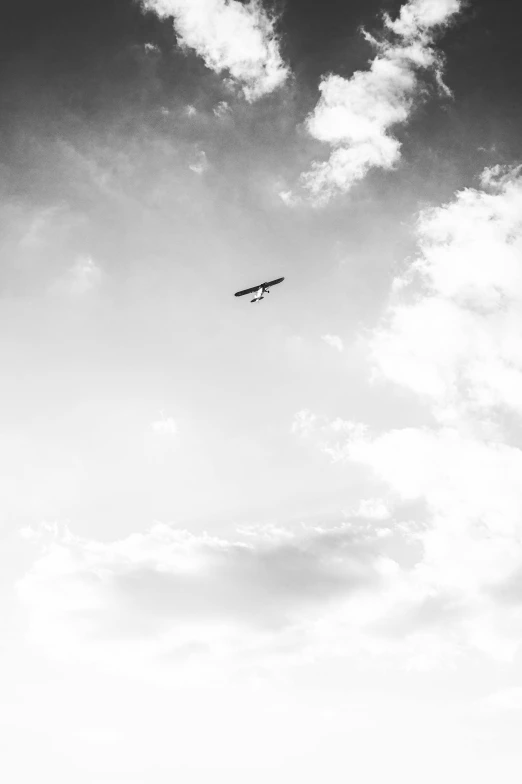 an airplane flying thru the air with fluffy clouds