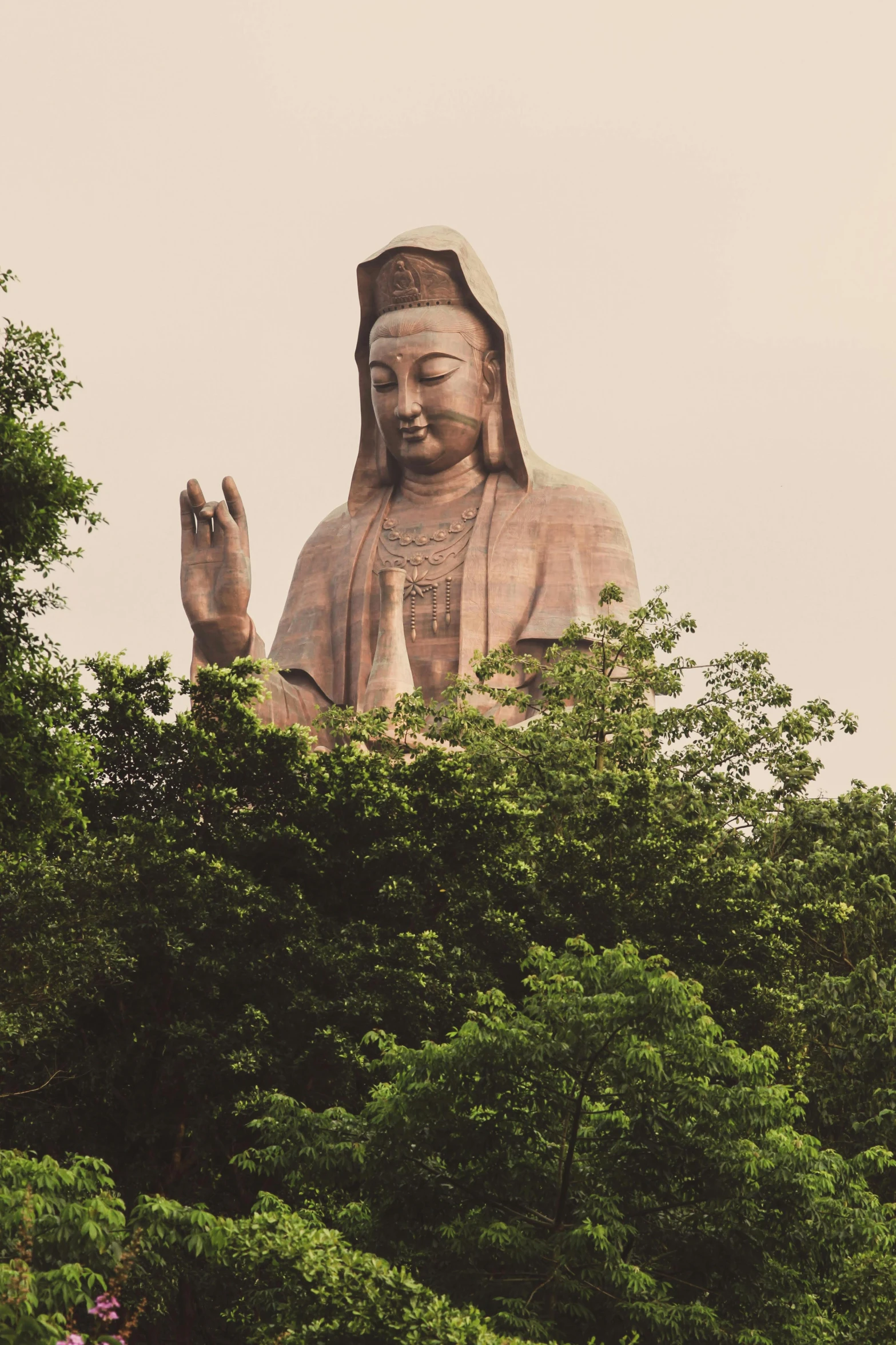 a big statue in the middle of some trees