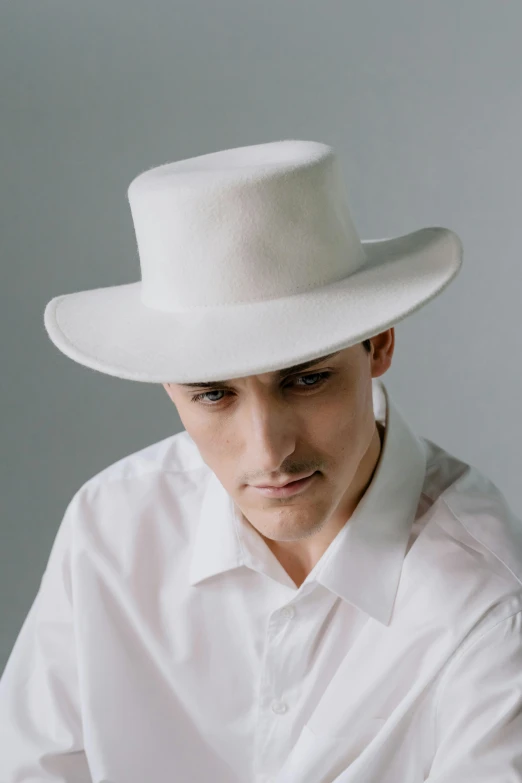 a man in a white shirt is wearing a hat