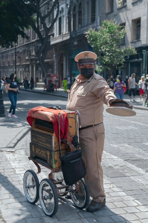 a man with a bicycle and tray in his hand is posing on a city street