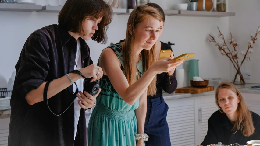 two women in blue dresses are standing near a table