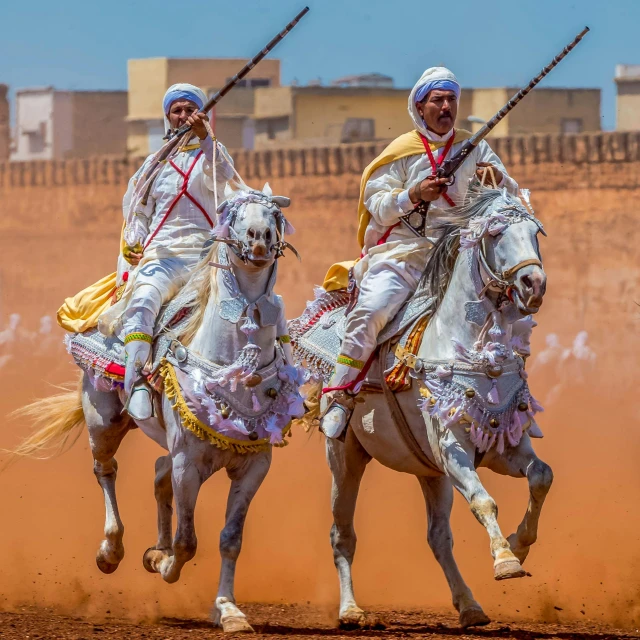 two men riding on the back of horses