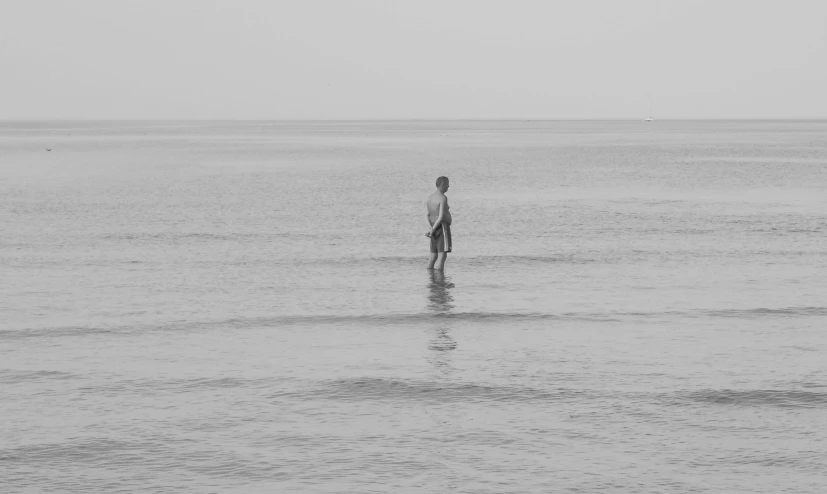 man standing in the middle of the ocean alone