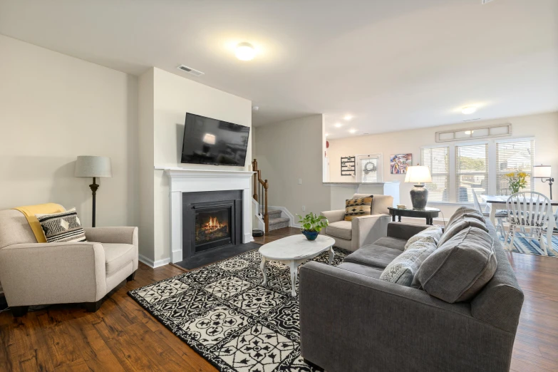 a living room area with two sofas, tv, table and fireplace