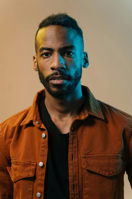 a man wearing a brown shirt and black shirt