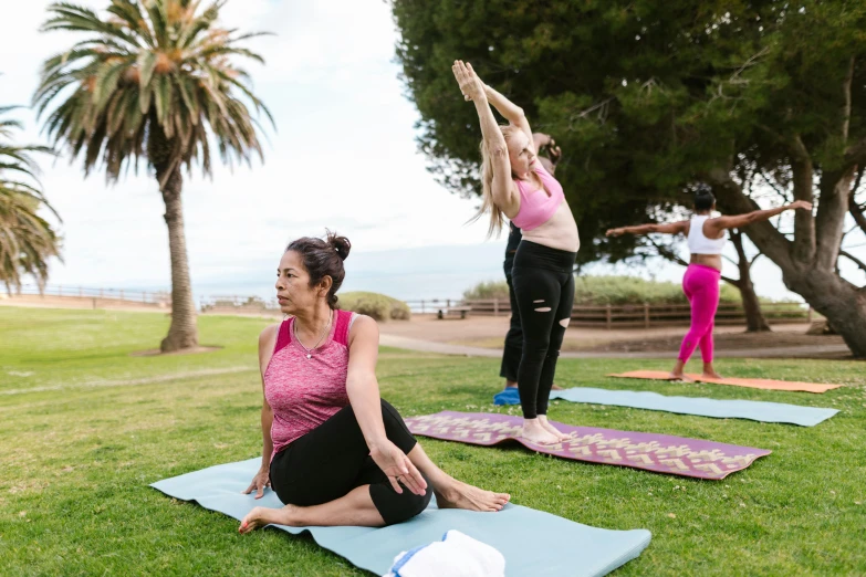 a woman doing a yoga pose on a lawn