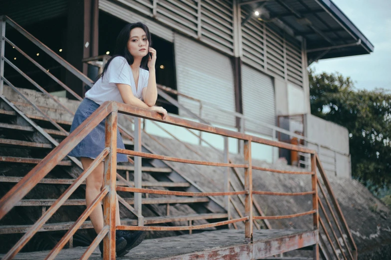 a woman talking on her phone while standing next to some steps