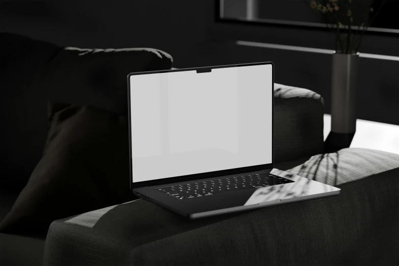an open laptop computer sitting on top of a black couch