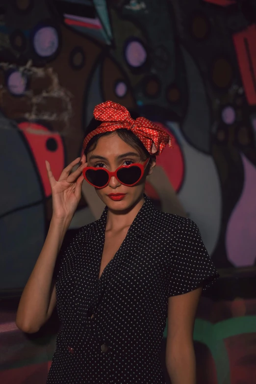 young woman with glasses and a bow on her head posing