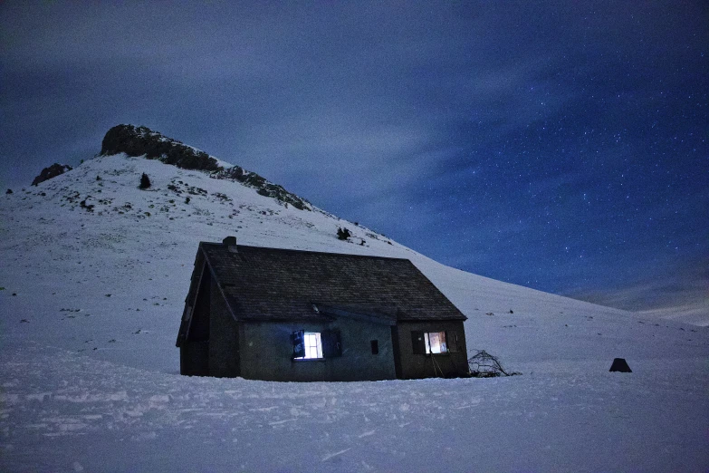 a house with the roof exposed on a snowy mountain