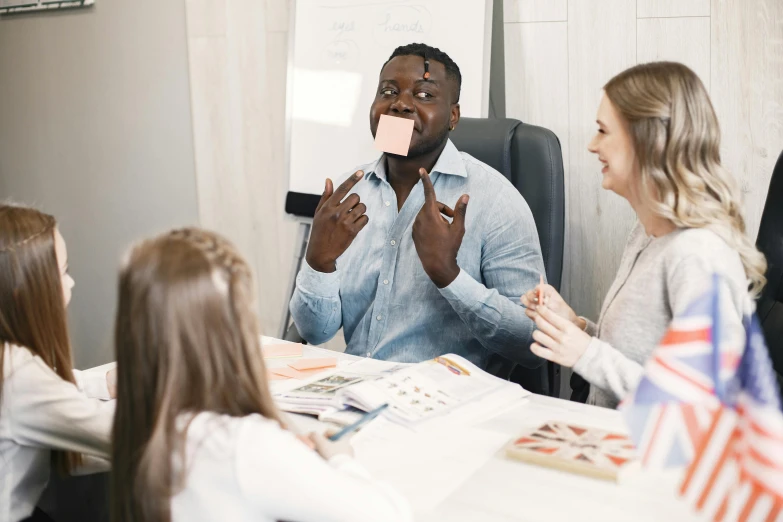 people are sitting around a table with a piece of paper in the middle of their hands