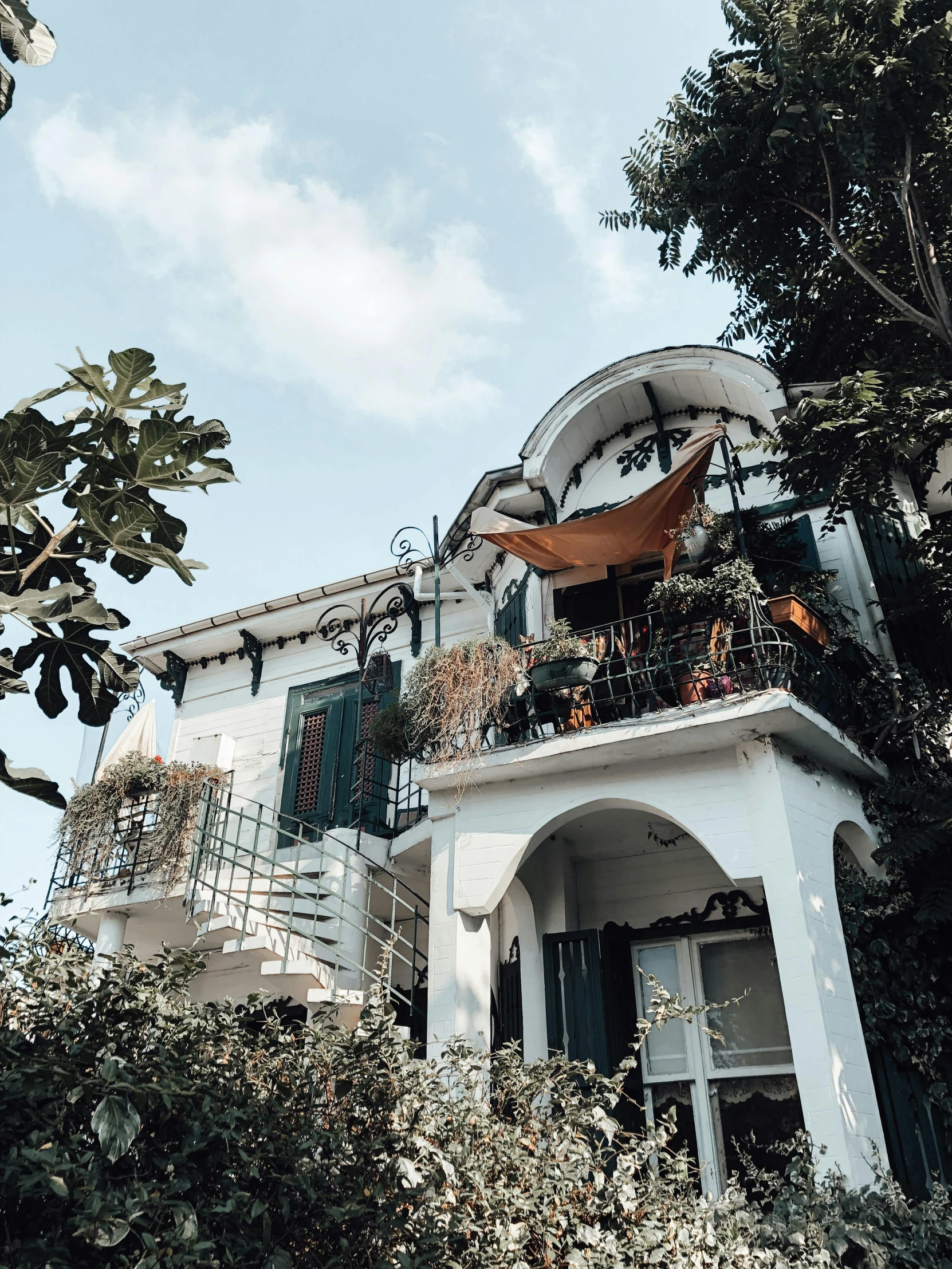 an old style house has green shutters on the balcony