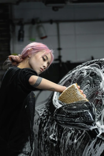a woman washing her car while she works