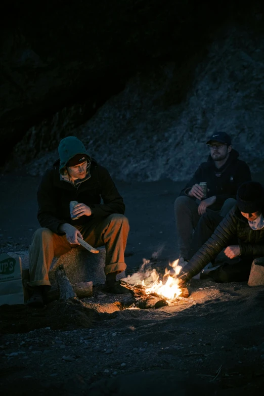 a group of people sitting around a campfire