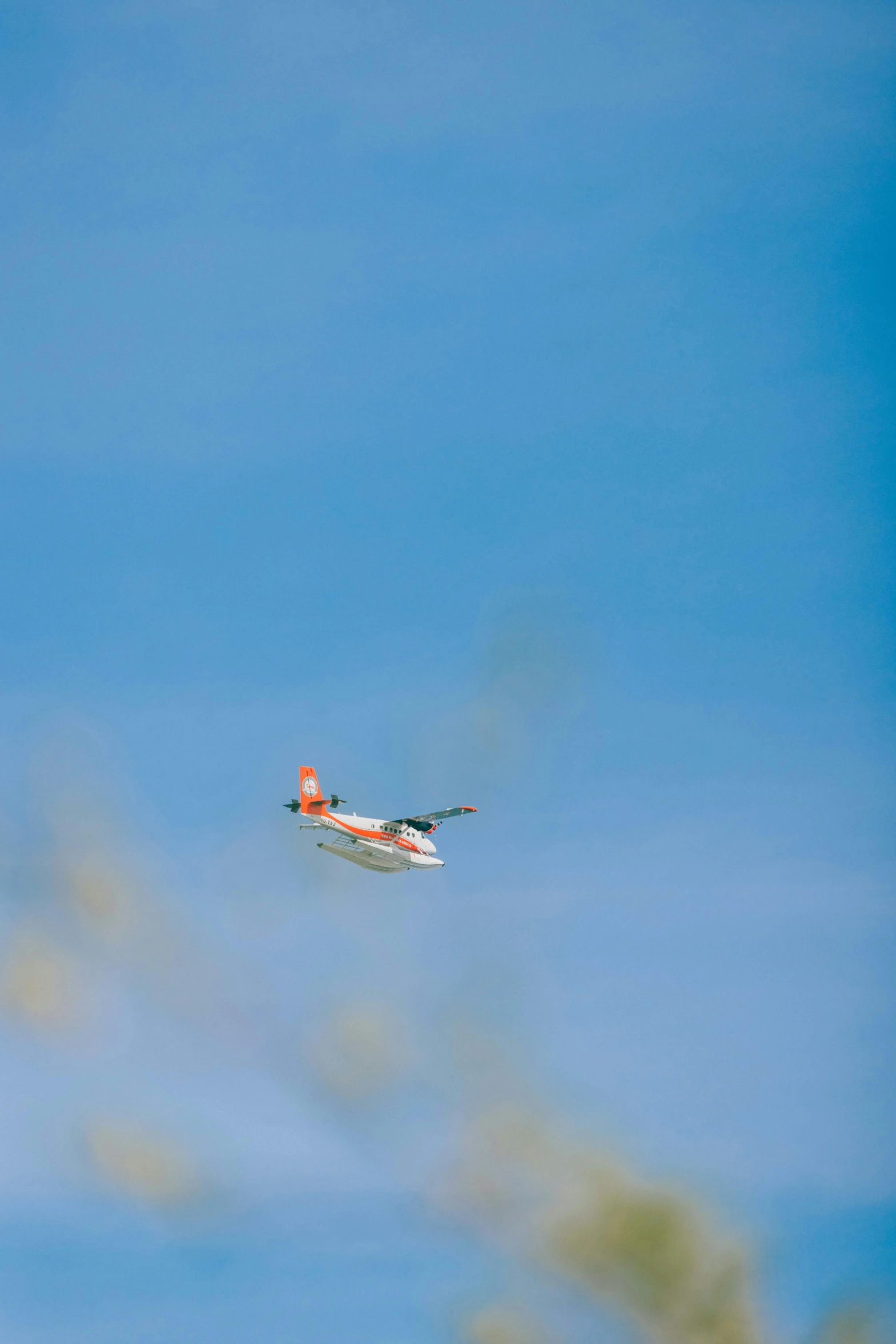 a small airplane flying through a blue sky