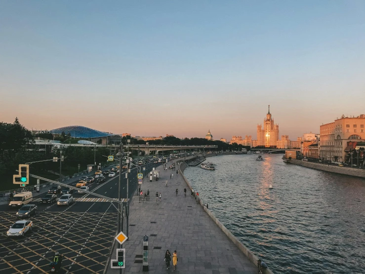 an urban area with many people walking by a waterway