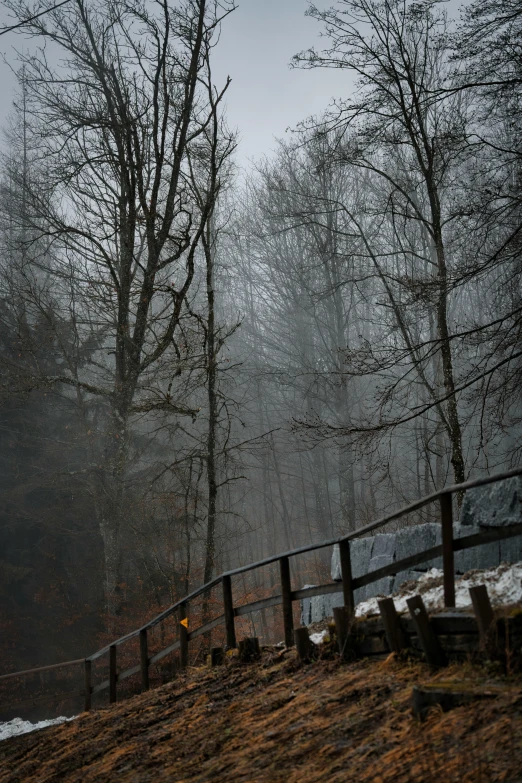 a fence sits on the side of a mountain near a path