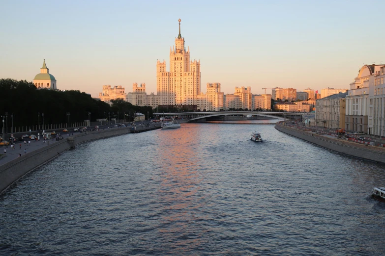 a small boat is going through the river by tall buildings