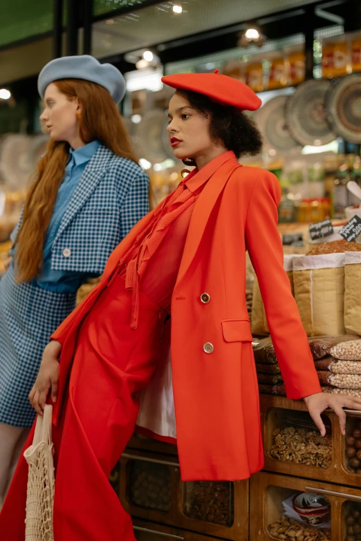 three women in colorful outfits are looking at the food display