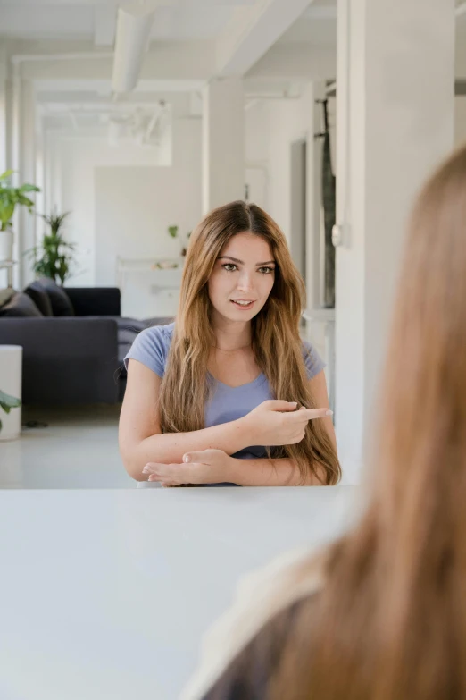 woman sitting at table pointing towards the other side