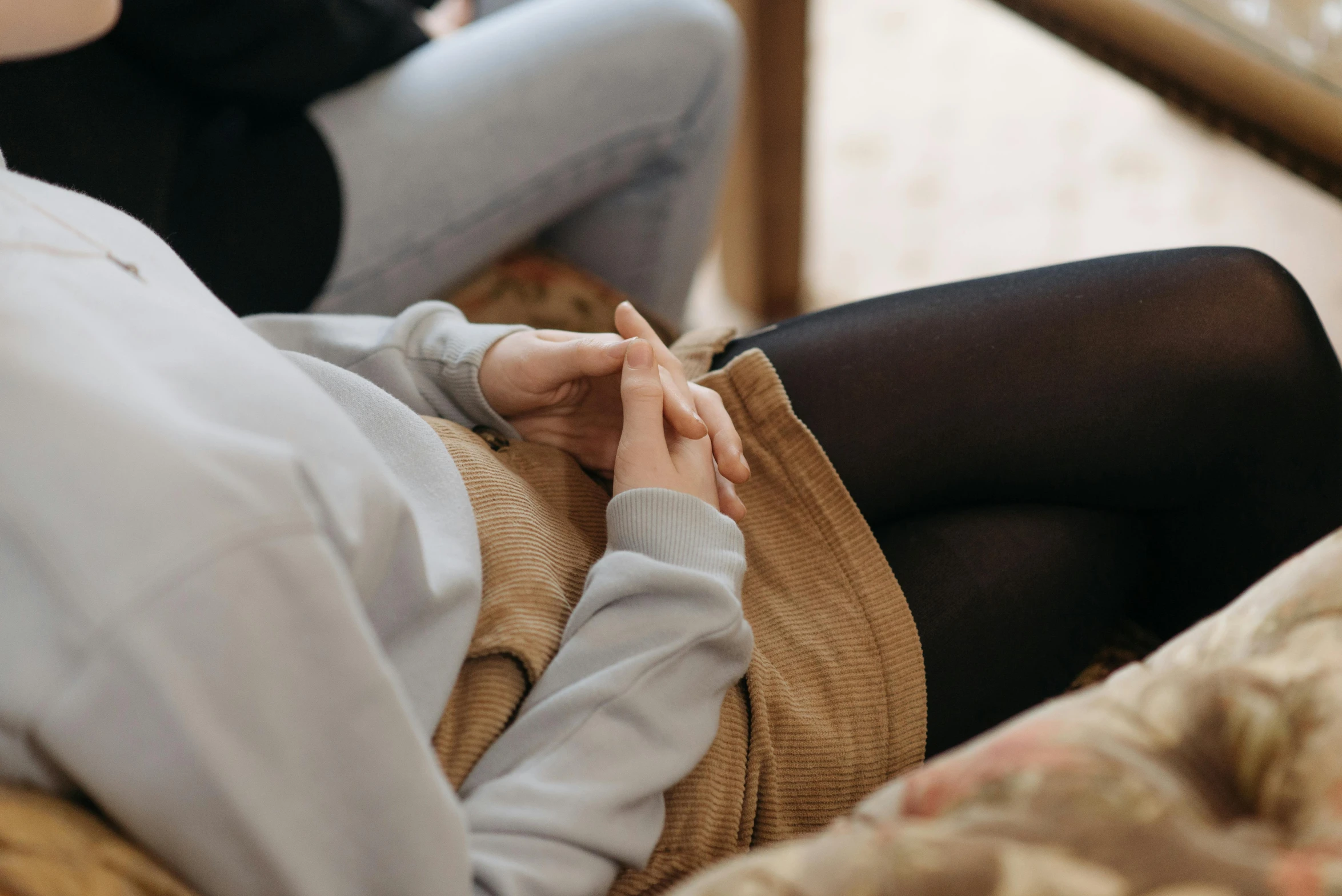 a pair of women in sweaters are sitting down