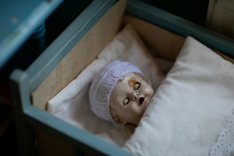 an old doll with torn hands is laying in a box