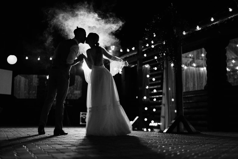 the bride and groom at the barn dancing together