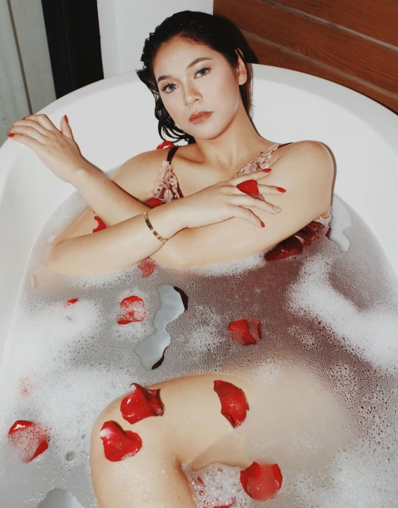 a woman in an old fashion bath tub with  on her knees