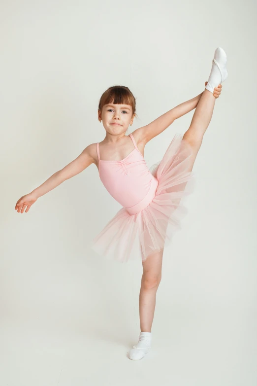 a small girl in pink leotard posing for a po