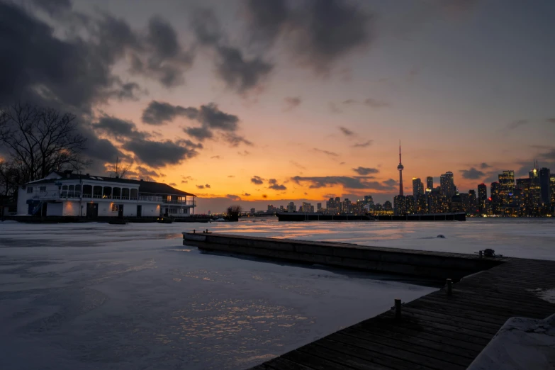 the sun sets in front of a skyline overlooking water