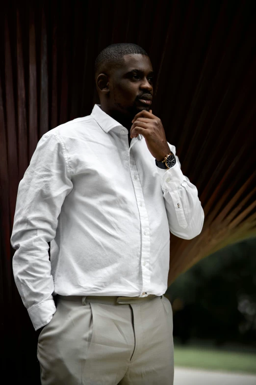 an african man wearing a white shirt and tan pants