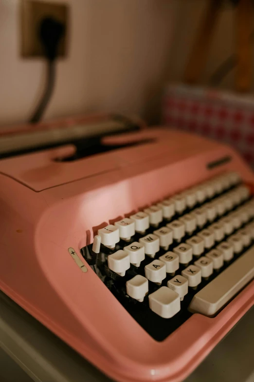 an old red typewriter sitting on top of a desk