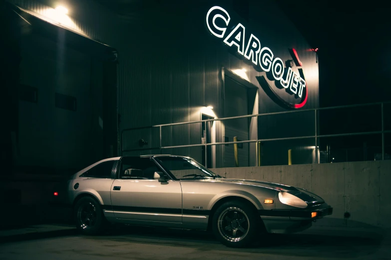 the sports car is parked in front of the neon sign