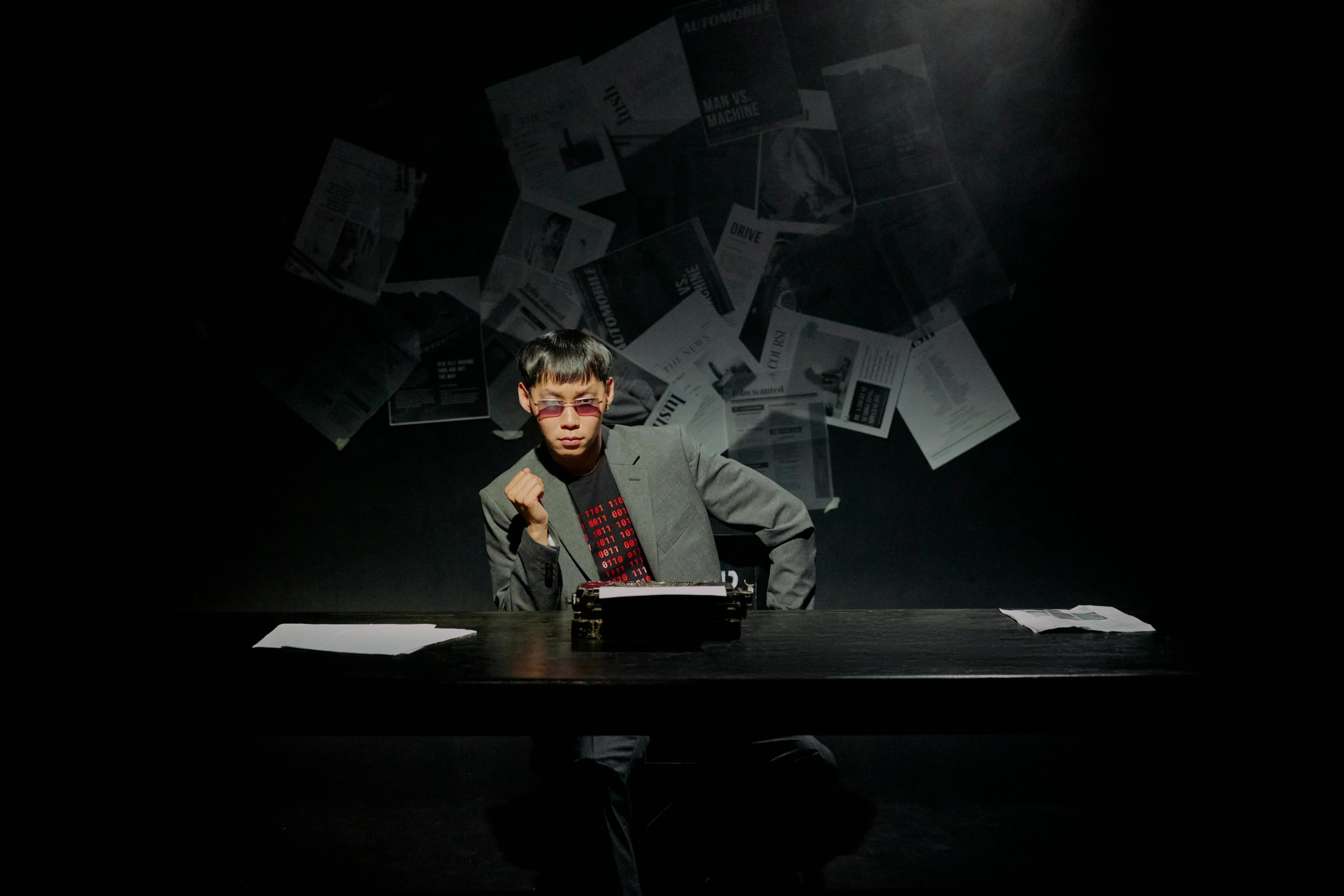 a man sitting at a black table in front of a laptop