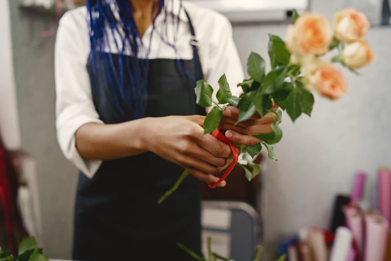 the woman is florising the roses off with the scissors