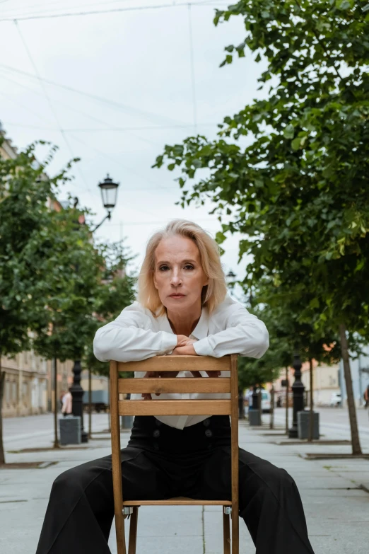 a woman sits in a chair on the sidewalk