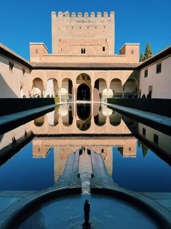 a reflection of the top of a tall building on water