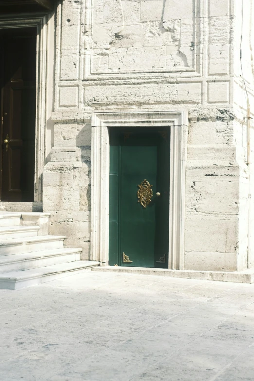 a green door in front of a brick building