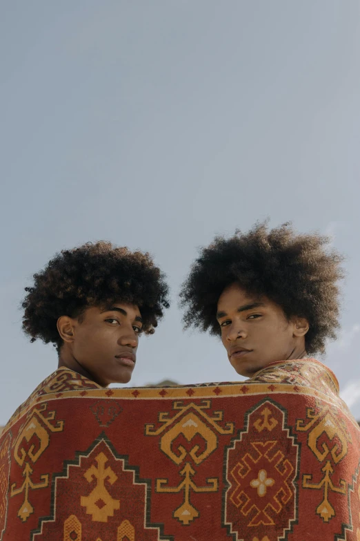 two men standing close to one another with afros on