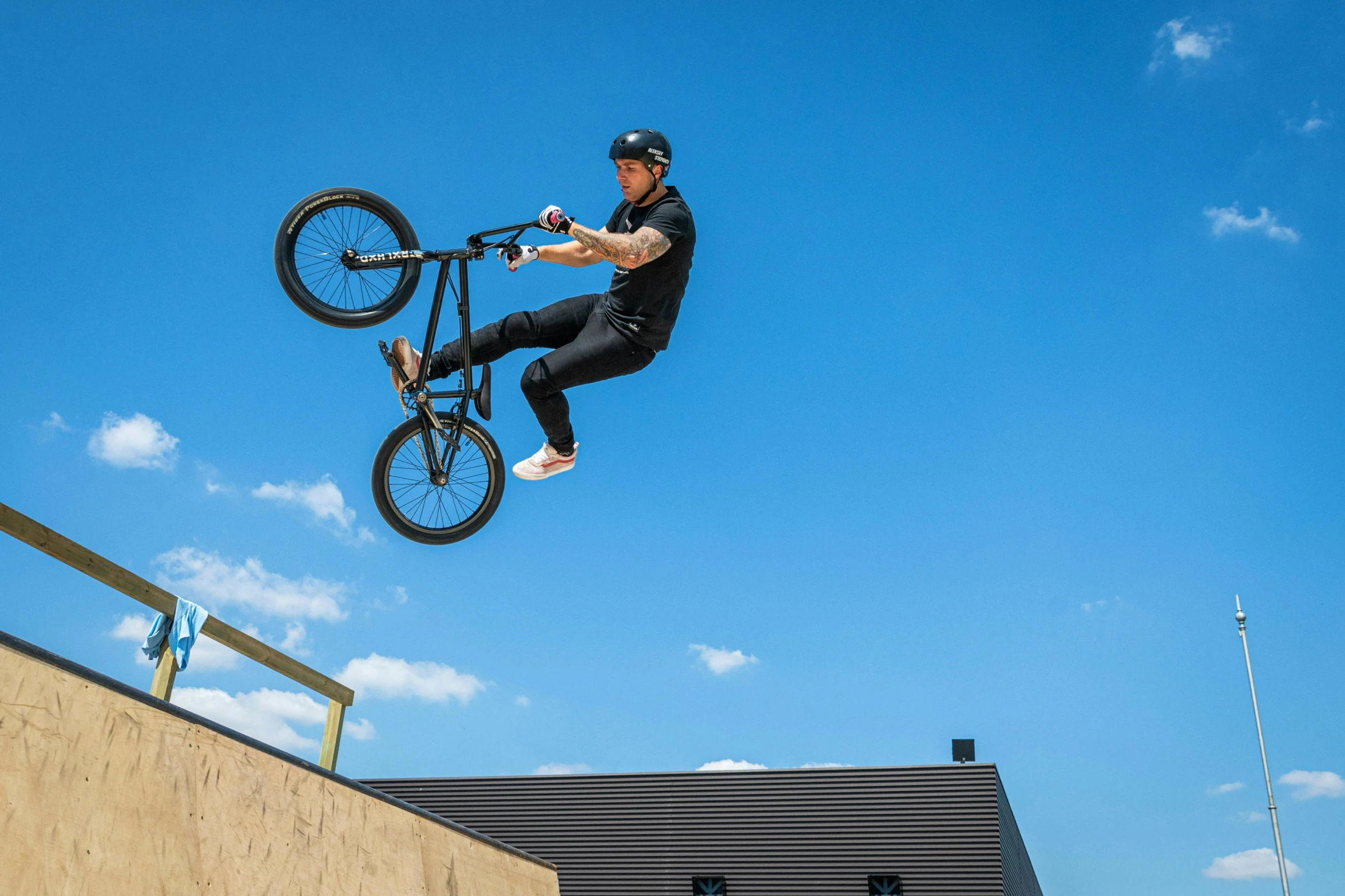 a man on a bike does a trick in the air