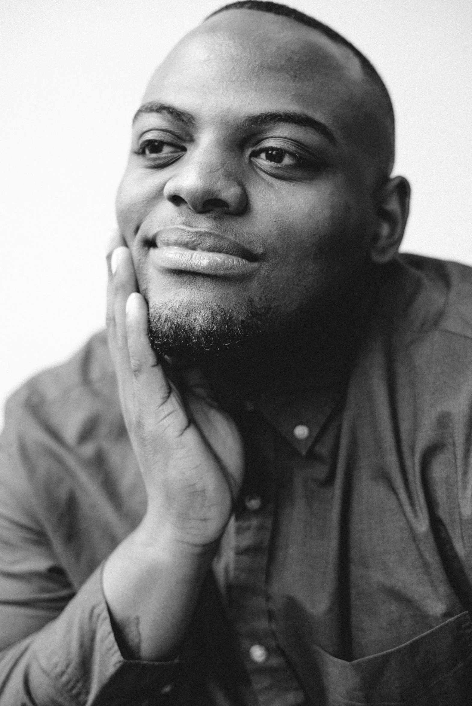 a man sitting with his hand near his chin