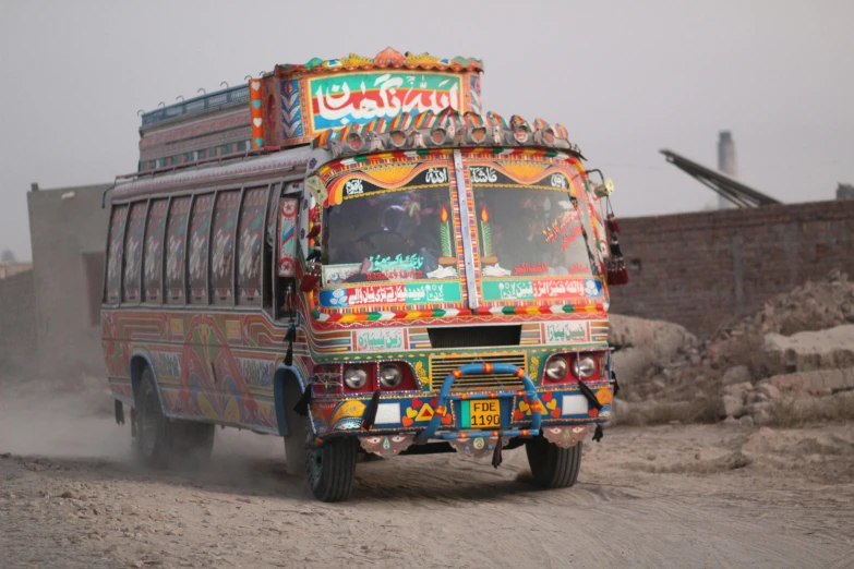 a truck made out of painted cars driving through a desert landscape